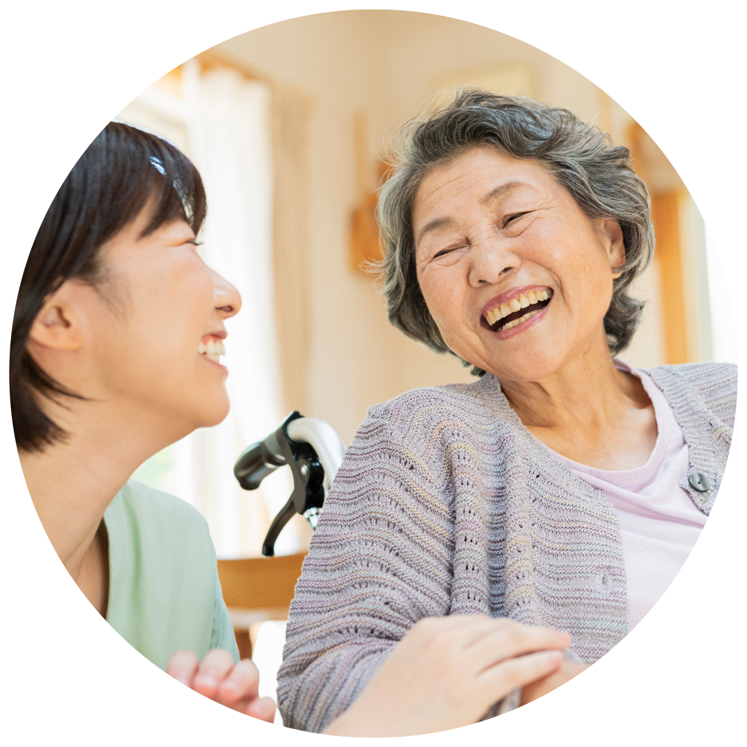 Two women laughing together in a room.