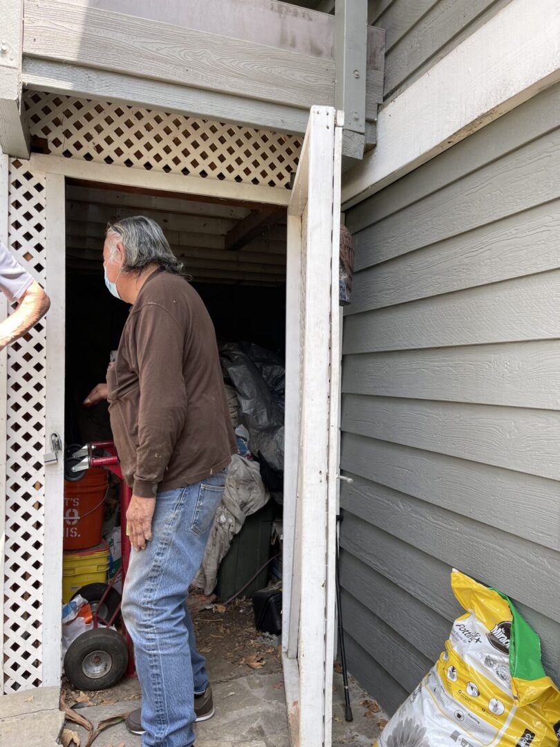 A man is walking into the garage of his house.