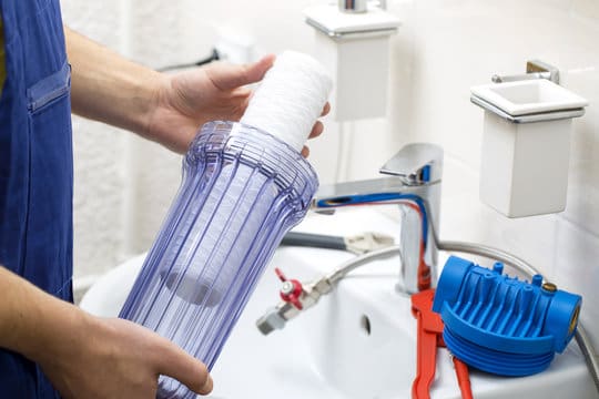 Person installing a water filter.