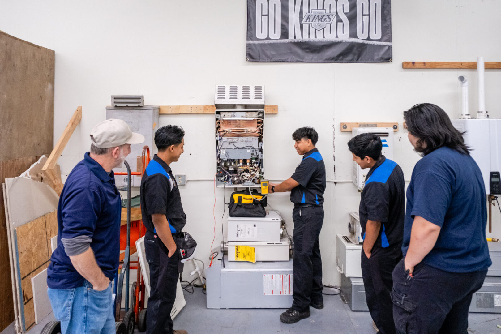 Four men working on a water heater.