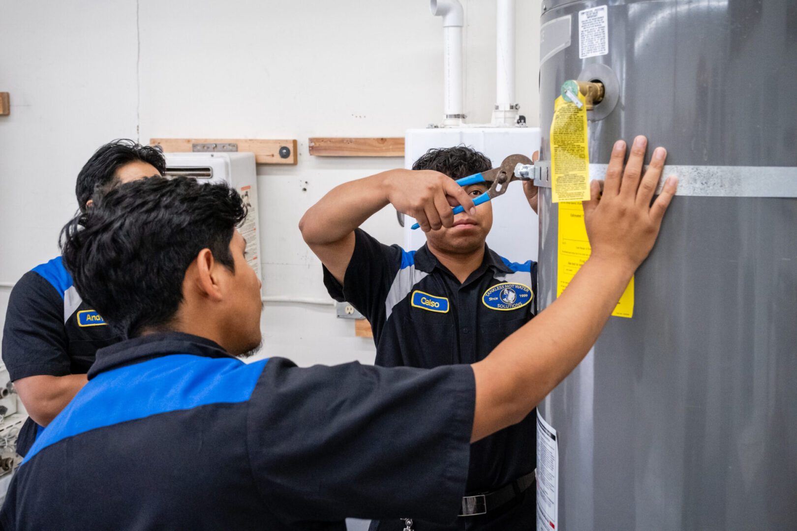 Two men working on a water heater.