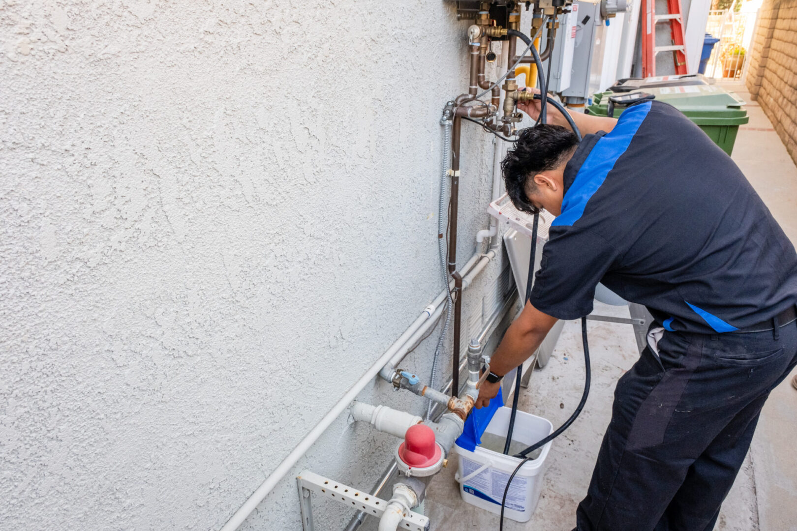 Plumber working on pipes outside.