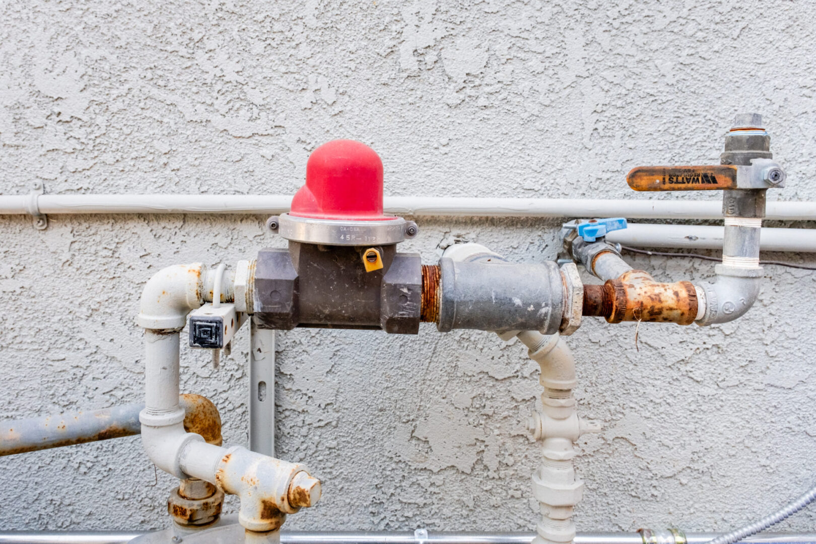 Water meter and pipes on a wall.