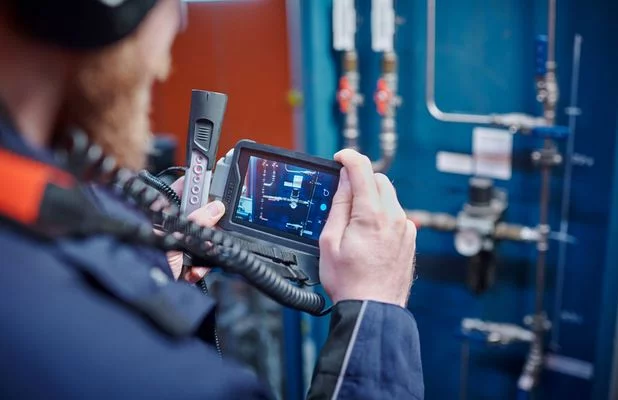 Man inspecting equipment with a camera